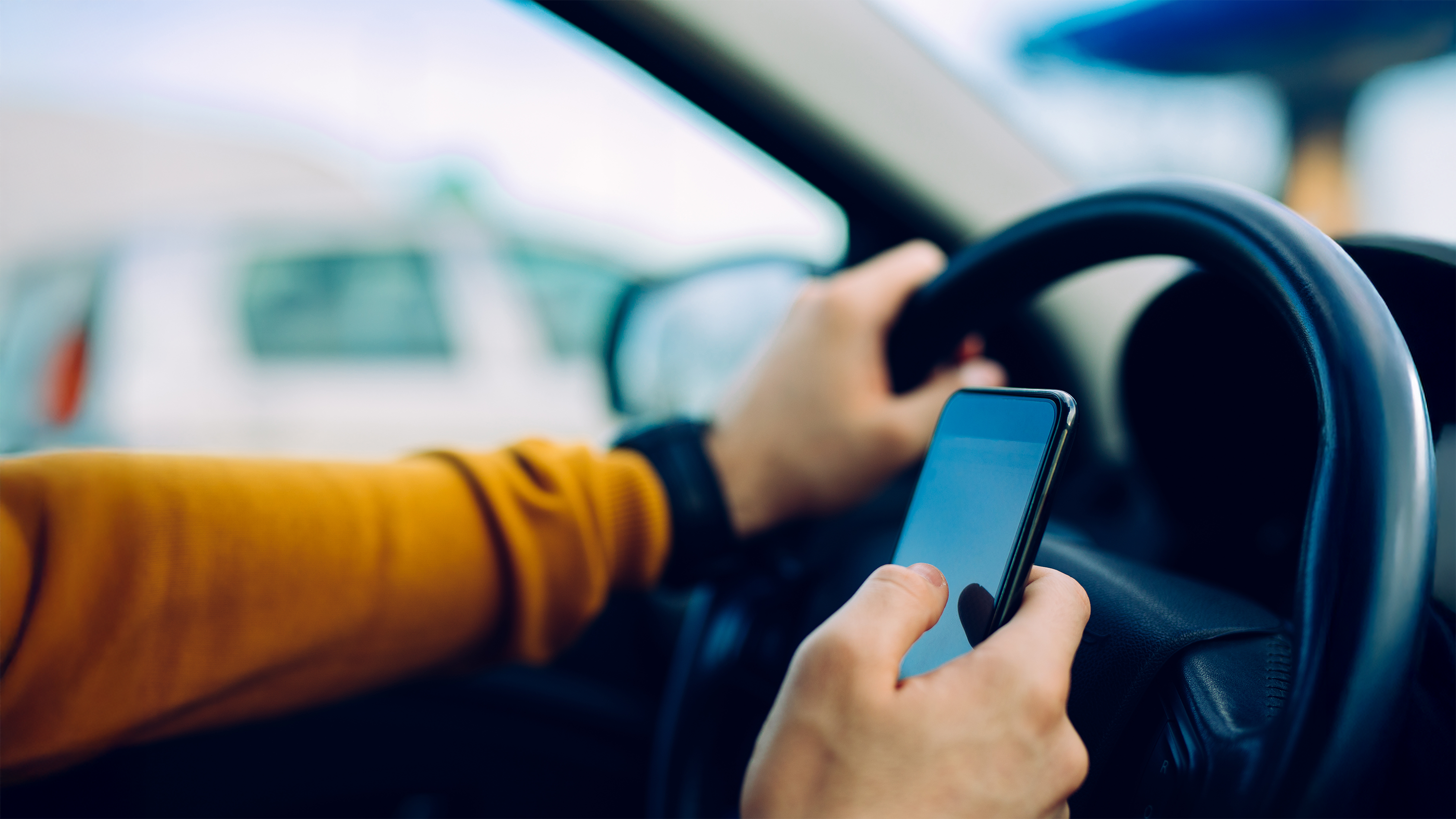 person holding cell phone while driving